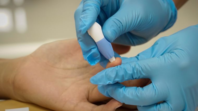 Close up on the hands of a health care worker taking a blood sample