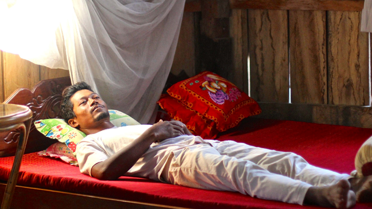 Malaria patient lying on a bed in Southeast Asia