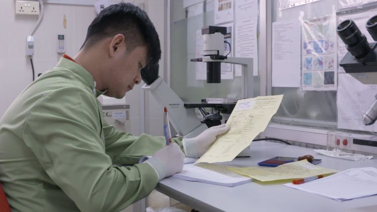 Researcher in a lab transcribing notes